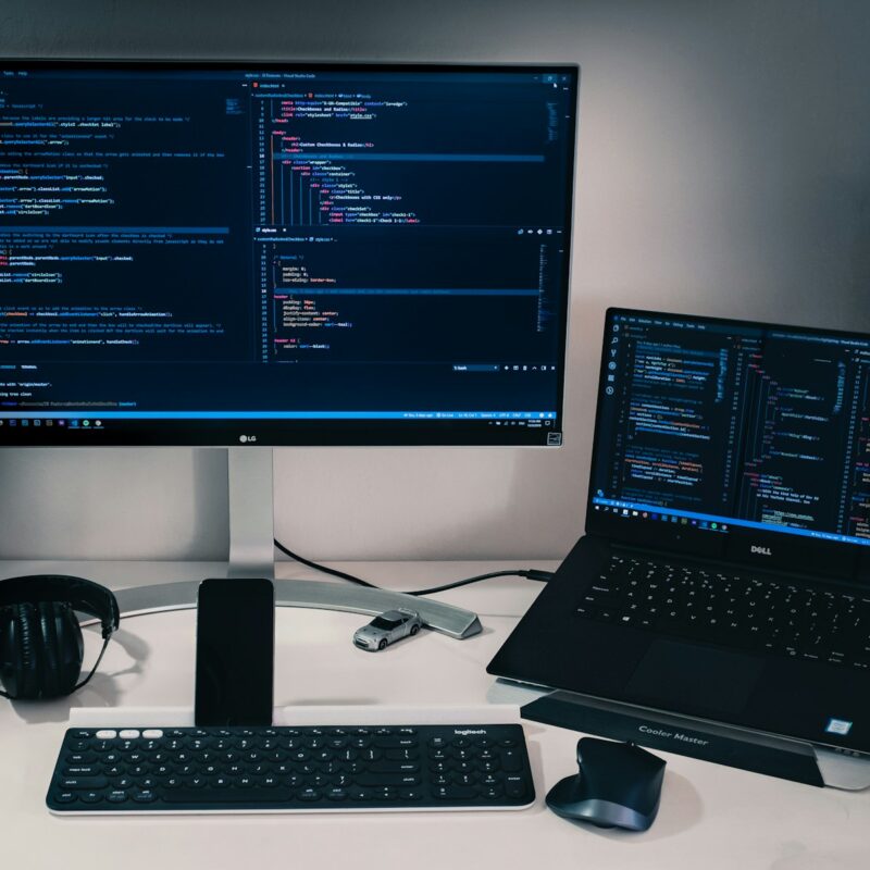 laptop computer beside monitor with keyboard and mouse